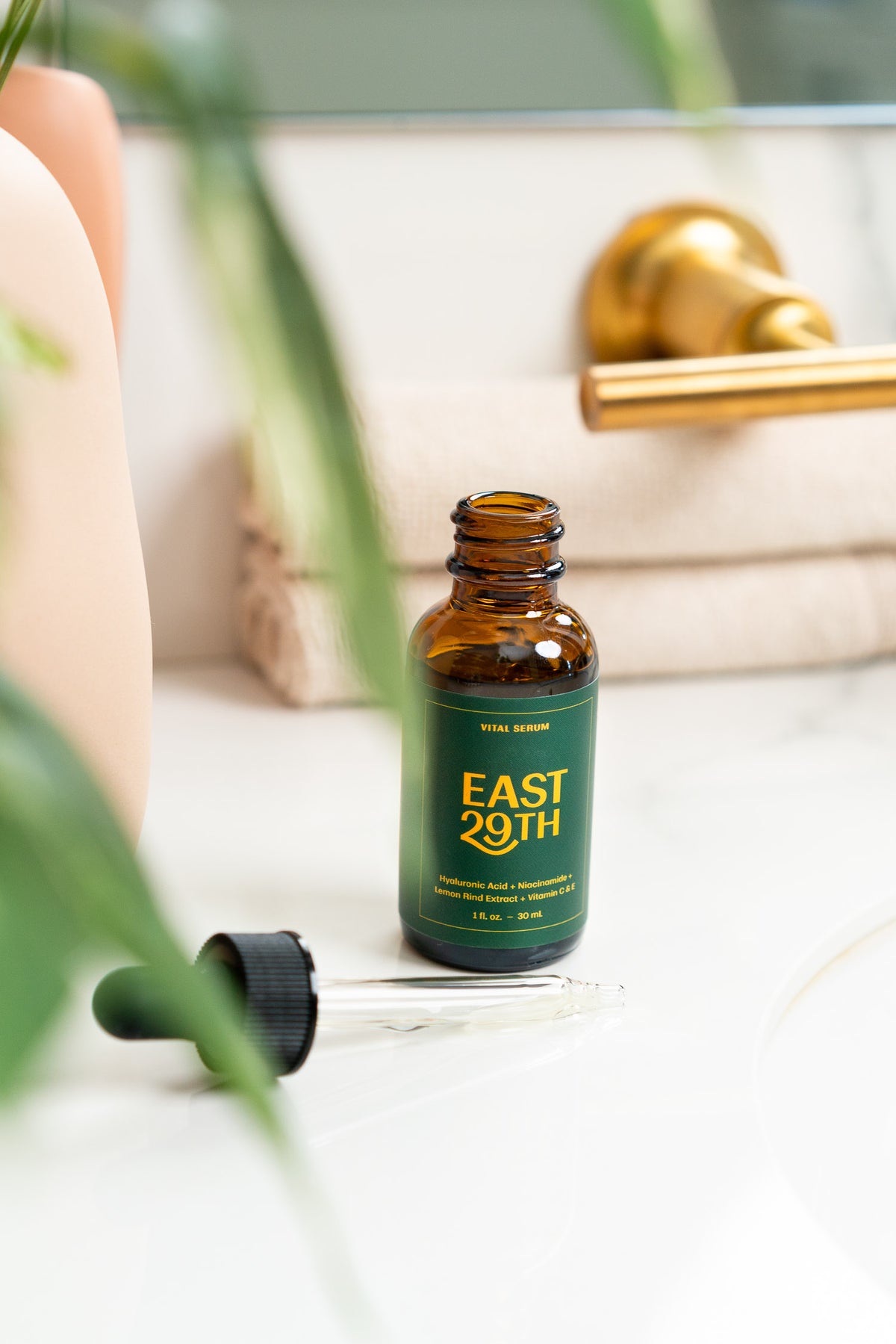 Hyaluronic Acid, Niacinamide, Vitamin C, Vitamin E, Lemon Rind Extract Serum in eco-friendly amber glass Skincare bottle.