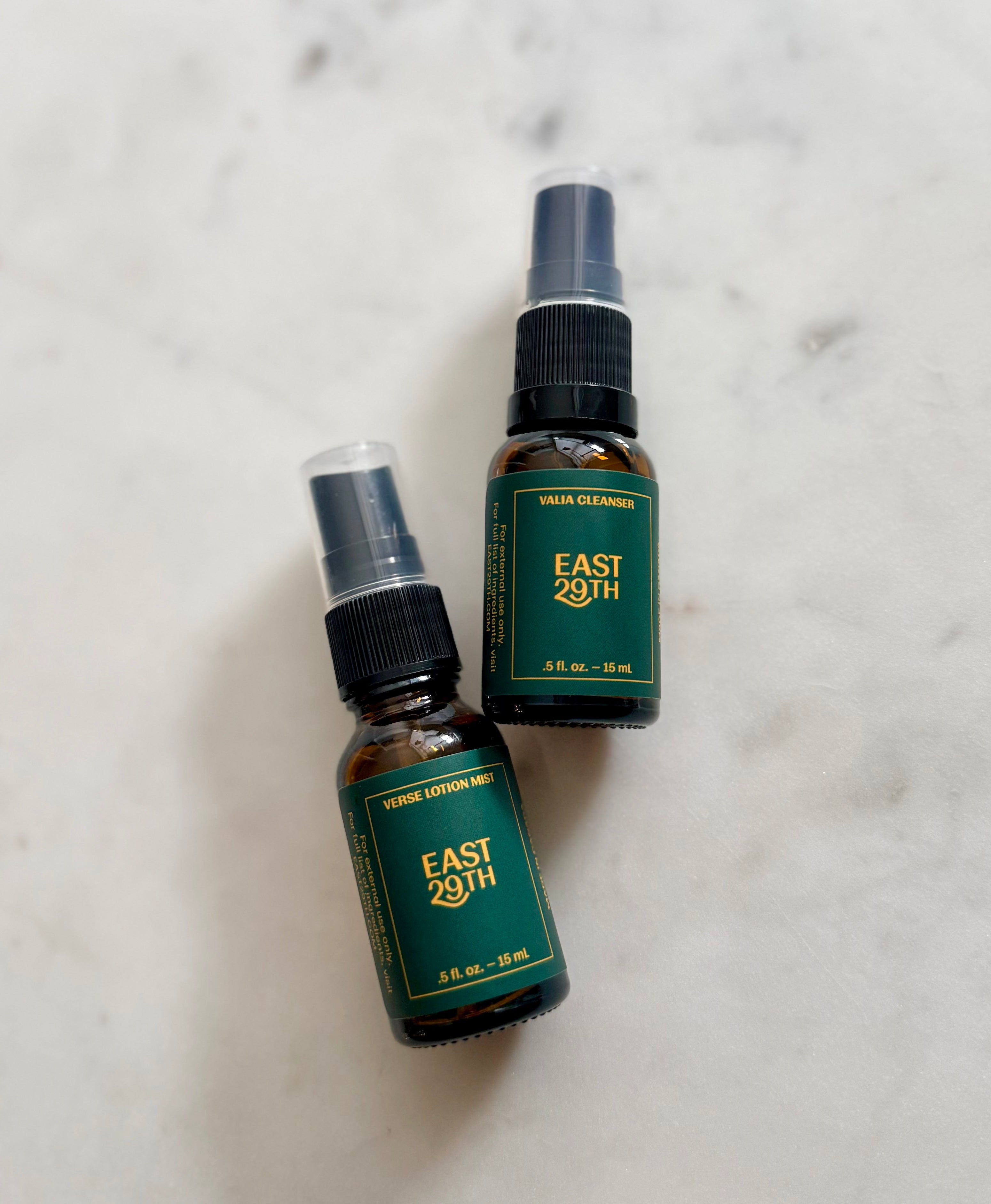 Two East 29th spray bottles on a marble surface